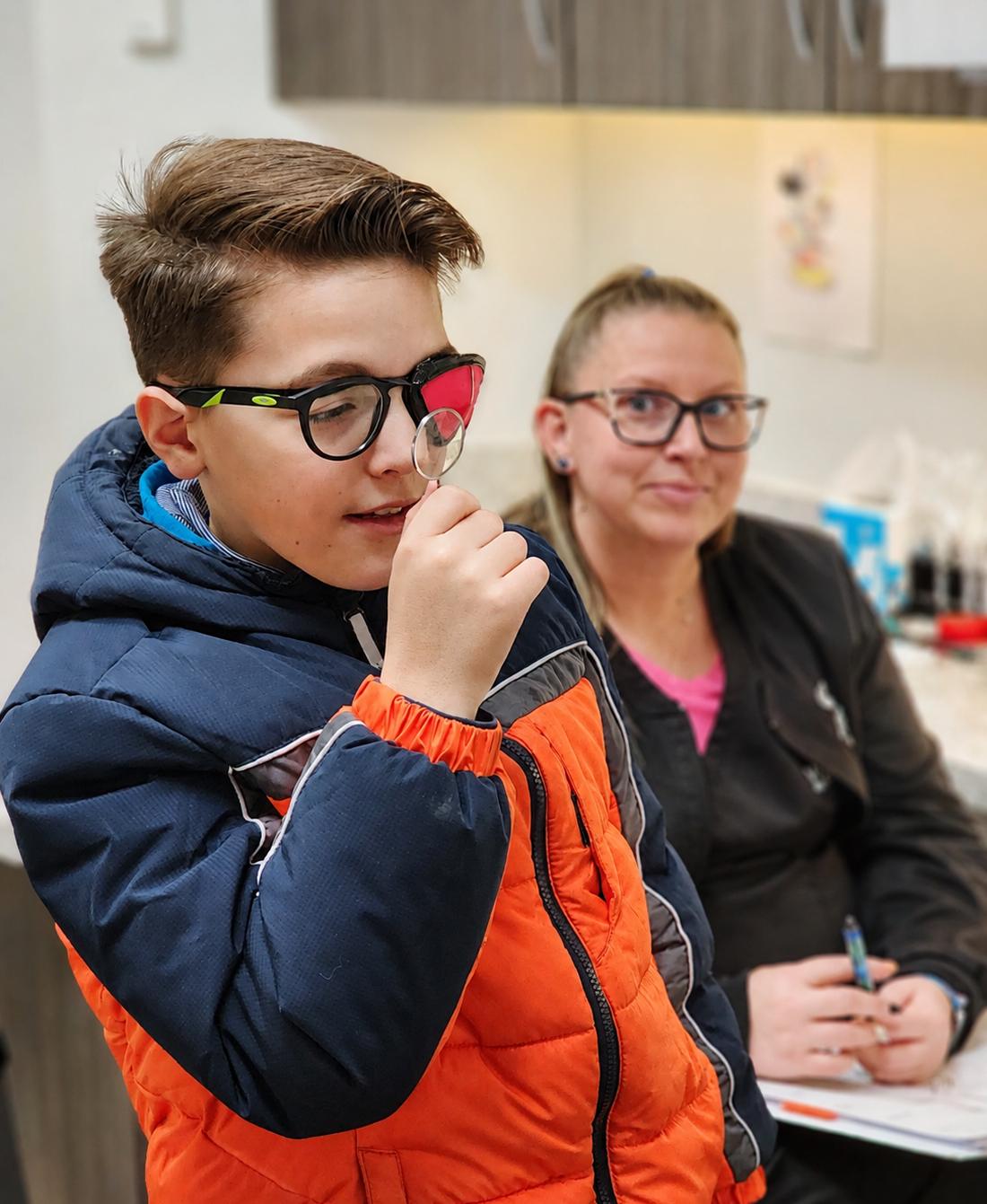 A Webb Eyecare vision therapist working with a young patient in glasses.