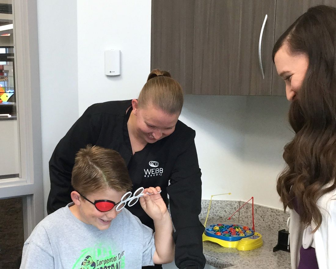 A child completing a vision therapy exercise with a Webb Eyecare therapist.