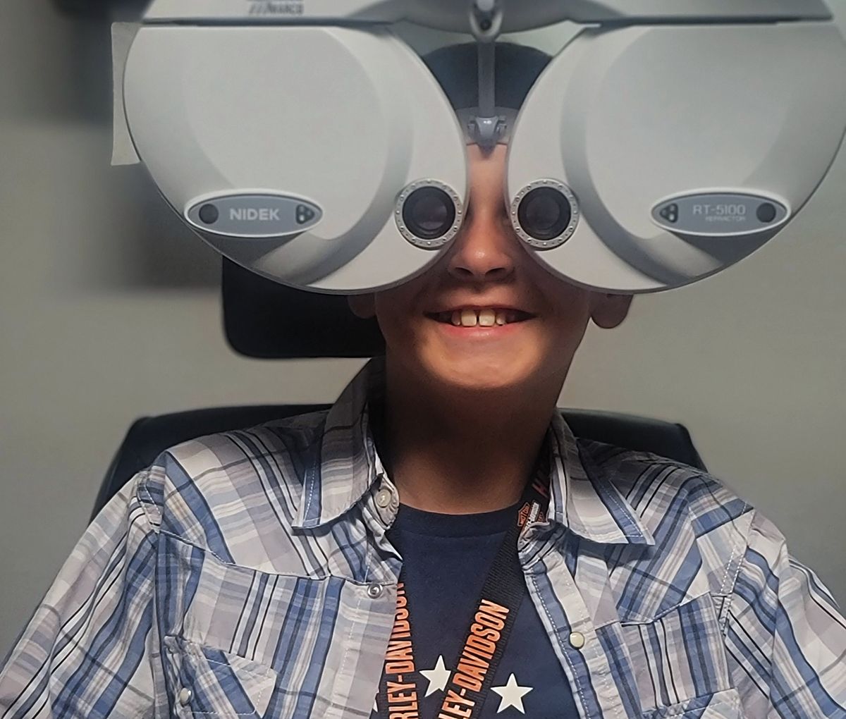 A patient looking through the phoropter during a comprehensive eye exam at Webb Eyecare.