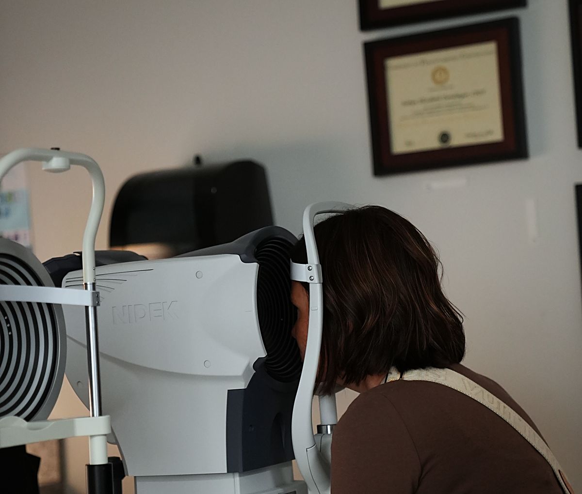 A Webb Eyecare patient having retinal images taken during a medical eye exam.