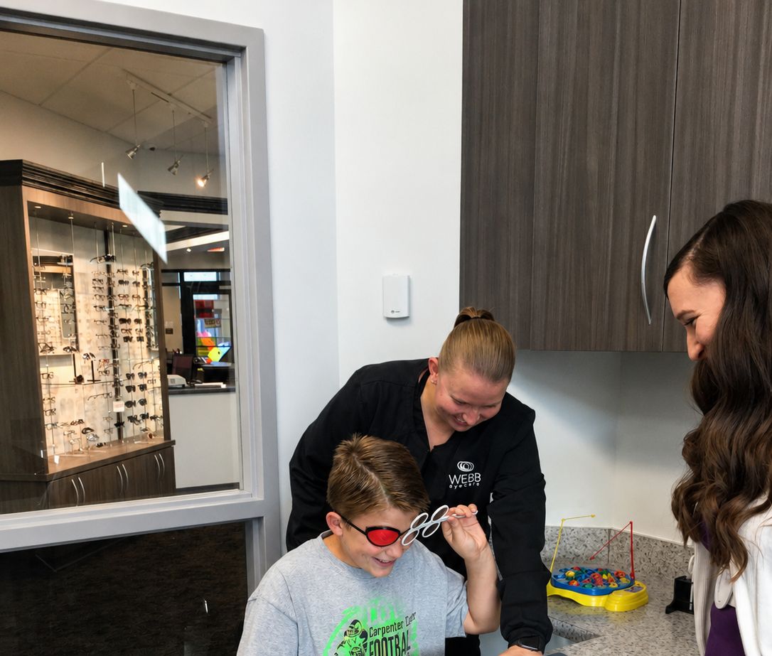 A Webb Eyecare team member walking a young patient through a vision exercise.